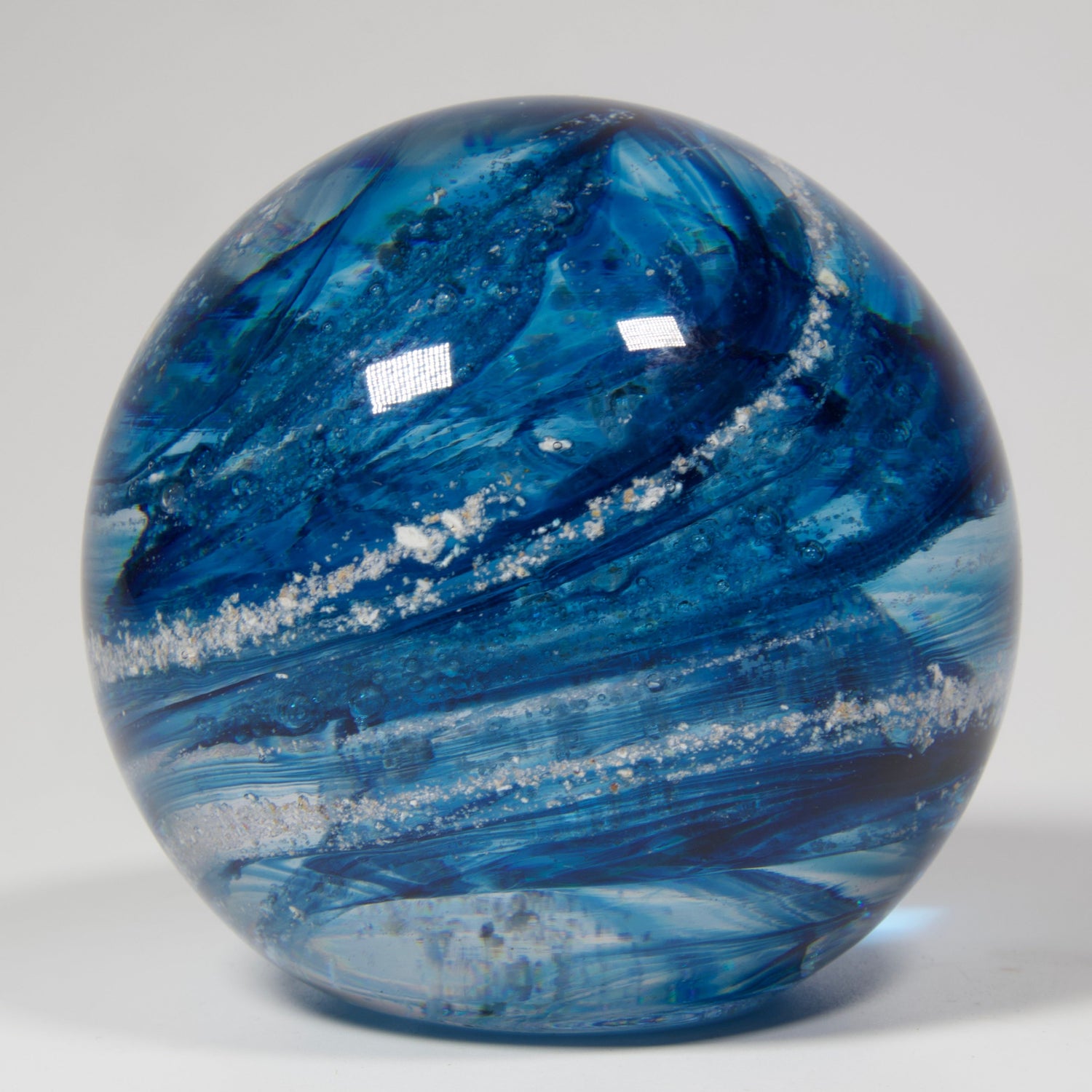 Blue round paperweight with ashes